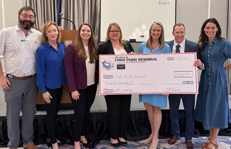 Tournament Board holding oversized check for $25,000.